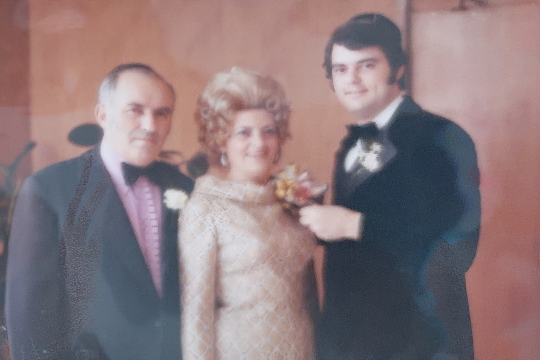 Morris standing between his parents at a wedding celebration